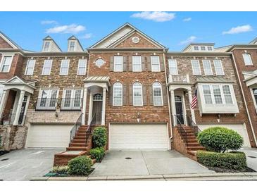 Charming brick townhome featuring a two-car garage and well-maintained landscaping at 5104 Leeshire Se Trl # 64, Atlanta, GA 30339