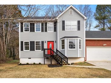 Charming two-story home with gray siding, black shutters, red front door, and attached two car garage at 4390 Allgood Pl, Stone Mountain, GA 30083