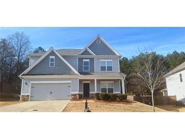 Two story house with gray siding, stone accents and a two-car garage at 6268 Odum Cir, Covington, GA 30014