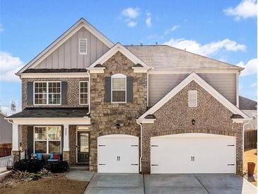 Charming two-story home features a stone and brick facade with a two-car garage and a welcoming front porch at 2527 Dayview Ln, Atlanta, GA 30331