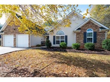 House exterior features stone accents, a two-car garage, and a landscaped yard at 117 Javay Ct, Villa Rica, GA 30180