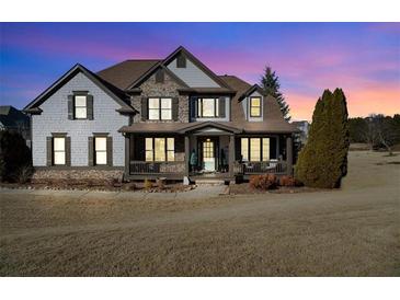 Two-story house with stone and shingle accents, and a wrap-around porch at 6610 Wesley Trail Holw, Cumming, GA 30028