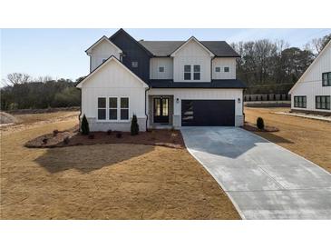Two-story farmhouse with gray siding, black accents, and a long driveway at 4265 Haynes Cir, Snellville, GA 30039