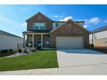 Two-story brick home with a large driveway and landscaped lawn at 309 Bowfin Trl, Mcdonough, GA 30253