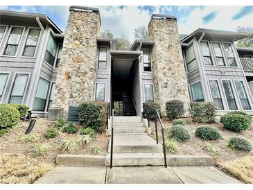 View of the condo's exterior featuring stone accents and landscaping at 4079 Woodridge Way, Tucker, GA 30084