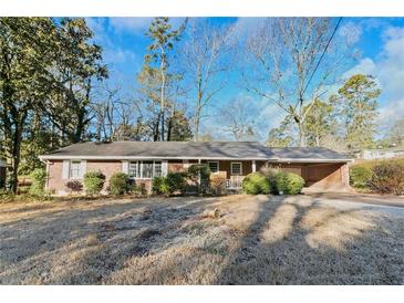 Charming single story home with a brick facade, covered carport, and a well-maintained lawn at 1405 Pinehurst Sw Dr, Atlanta, GA 30311