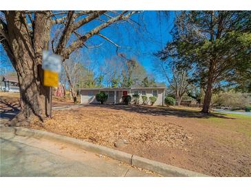 Charming single story home with mature trees and a well-maintained lawn on a sunny day at 16 Bromack Se Dr, Atlanta, GA 30315