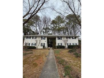 Two-story building with a walkway, landscaping, and mature trees at 809 Jordan Ln # K3, Decatur, GA 30033