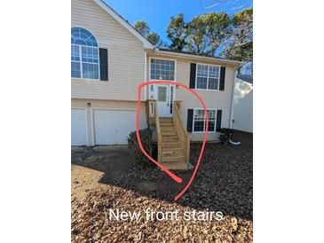 House exterior featuring new front stairs and a two-car garage at 2331 Rambling Way, Lithonia, GA 30058