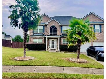 Brick two-story house with palm trees and a large yard at 160 Oak Manor Dr, Covington, GA 30016