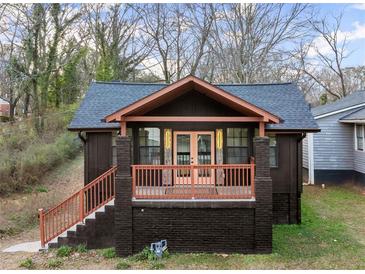 Charming renovated bungalow with a modern dark exterior, welcoming front porch, and landscaped yard at 2049 Meador Se Ave, Atlanta, GA 30315