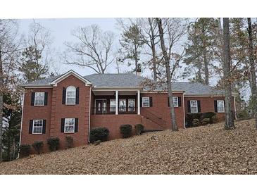 Brick house with a large covered porch and attached two-car garage at 1050 Wiley Bridge Rd, Woodstock, GA 30188