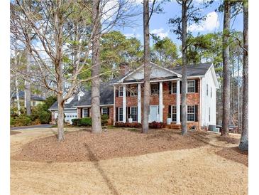 Charming two-story brick home with white columns and a well-manicured front yard at 1579 Howell Highlands Dr, Stone Mountain, GA 30087