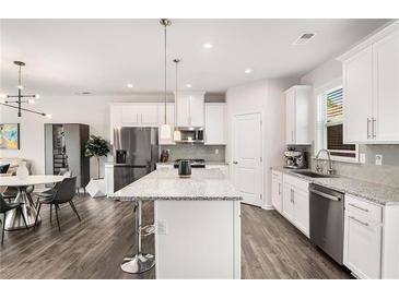 Bright kitchen features stainless steel appliances, granite counters, and a center island with barstool seating at 1590 Ridgebrook Downs, Mableton, GA 30126