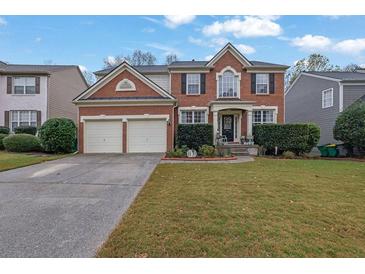 Brick two-story house with a two-car garage and manicured lawn at 615 Keeneland Ter, Woodstock, GA 30189