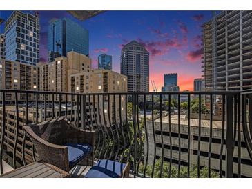 City view from balcony, with wrought iron and chair set during a beautiful sunset at 195 14Th Ne St # 902, Atlanta, GA 30309