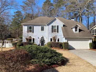 Charming two-story home with landscaped yard, mature trees, and attached two-car garage at 5440 Cameron Forest Pkwy, Johns Creek, GA 30022