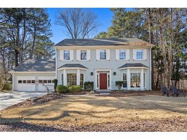 Charming two-story home featuring a well-maintained lawn and attached two car garage at 450 Surveyors Pt, Suwanee, GA 30024