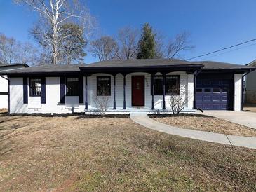 Charming ranch home features white brick, dark trim, and a red door at 6030 Danbury Ct, Morrow, GA 30260