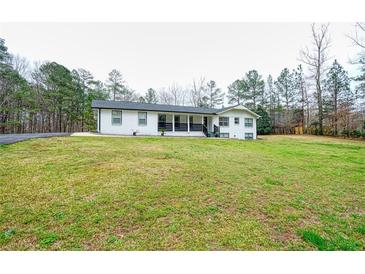 Charming white brick home with black accents, front porch, and spacious lawn at 218 Ward Rd, Ellenwood, GA 30294