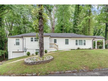 Charming white ranch home with a spacious yard and carport at 2705 Baker Ridge Nw Dr, Atlanta, GA 30318