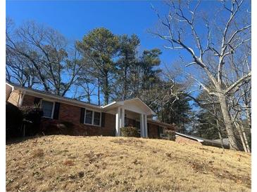 Brick ranch home with covered porch and mature trees on a large lot at 4315 York Rd, Atlanta, GA 30337