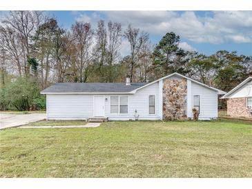 White single story home with stone facade and landscaped yard at 5815 Feldwood Rd, Atlanta, GA 30349