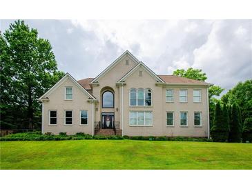 Brick two-story house with a large front yard and mature trees at 2120 Shaffer Rd, Cumming, GA 30041