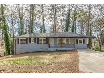 Newly renovated ranch home with gray brick exterior, modern porch, and long driveway at 1707 Boulderview Se Dr, Atlanta, GA 30316