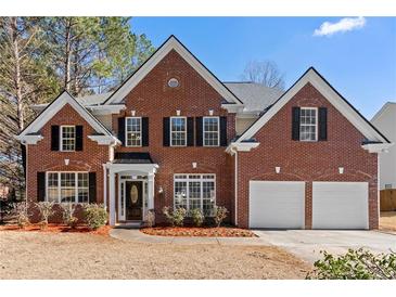 Brick two-story house with a three-car garage and manicured lawn at 115 Parkside Close, Alpharetta, GA 30022