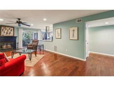 Bright living room features hardwood floors, fireplace, and access to a balcony at 64 Devon Ln, Avondale Estates, GA 30002