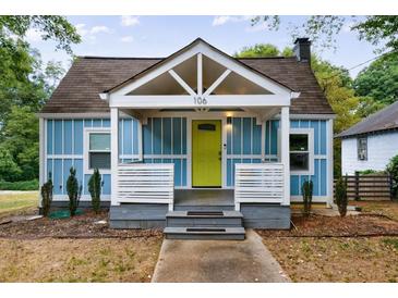 Charming light blue cottage with a bright yellow door and white trim at 106 Adair Ave, Atlanta, GA 30315