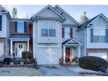 Two-story townhome with gray siding, red door, and attached garage at 3756 Harvest Dr, Atlanta, GA 30034