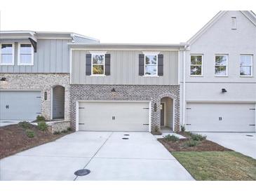 Brick front exterior of townhome with attached garage and landscaping at 1608 Ruskin Way, Marietta, GA 30062