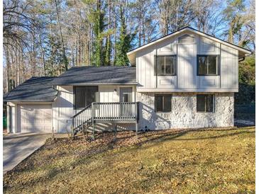 Two-story house with stone and white siding, gray deck, and attached garage at 517 Stonehedge Dr, Stone Mountain, GA 30087