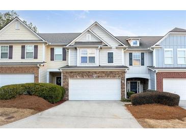 Attractive three-unit townhome development, featuring two-story homes with attached garages at 704 Woodland Pl, Woodstock, GA 30188