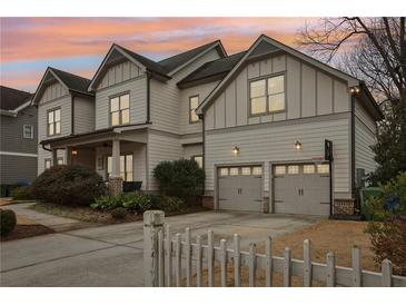 Two-story house with gray siding, two-car garage, and white picket fence at 370 Park Ne Pl, Atlanta, GA 30317