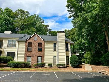 Two-story condo building with brick and siding exterior, surrounded by lush trees at 798 Windchase Ln, Stone Mountain, GA 30083