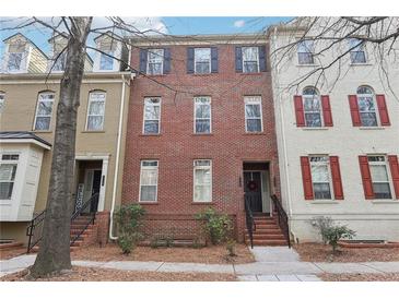Charming three-story brick townhouse with black shutters and well-maintained landscaping at 2732 Wander Ln, Alpharetta, GA 30022