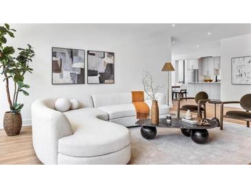 Bright living room features a modern curved couch, stylish decor, and hardwood floors at 2575 Peachtree Ne Rd # 6G, Atlanta, GA 30305