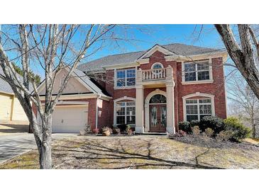 Brick two-story house with a three-car garage and landscaping at 3120 Esplanade Sw Cir, Atlanta, GA 30311