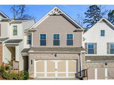 Charming townhome featuring a two-car garage and craftsman-style detailing on the exterior at 340 Cherryhill Ln, Woodstock, GA 30188