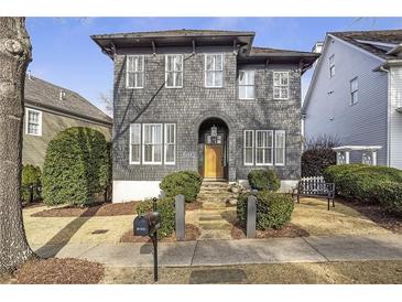 Charming two-story home with gray shingles, white trim, arched entryway, and manicured front yard at 5812 Long Park Rd, Cumming, GA 30040