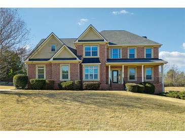 Traditional brick home with manicured front lawn and inviting covered porch, perfect for a growing Gathering at 328 Thistlewood Run, Mcdonough, GA 30252