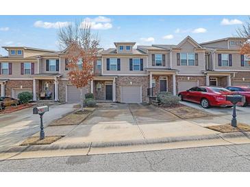 Attractive townhomes featuring attached garages, well-maintained landscaping, and welcoming front entrances at 2725 Morgan Glen Rd, Buford, GA 30519