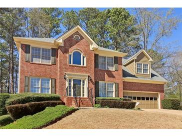 Charming two-story brick home with a well-manicured lawn and attached two car garage at 1150 Cedar Bluff Sw Trl, Lilburn, GA 30047