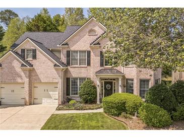 Charming two-story brick home with well-manicured lawn and a two-car garage provides an inviting curb appeal at 6615 Hampton Rock Ln, Cumming, GA 30041
