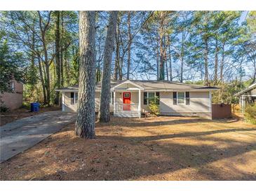 Charming single-story home featuring a bright red front door and a cozy front porch at 3881 Bonnie Se Ln, Atlanta, GA 30354