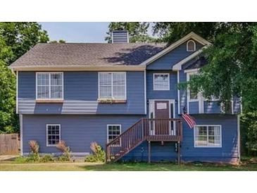 Charming two-story home with blue siding, updated windows, wooden deck, and a well-maintained lawn at 1469 Harmony Grove Church Rd, Auburn, GA 30011