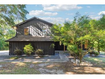 Two-story house with dark siding, landscaping, and a walkway at 9115 Pool Rd, Villa Rica, GA 30180